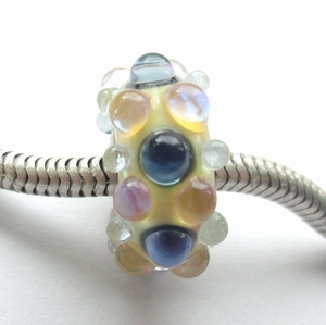 Ivory with shiny blue and yellowish silver glass dots